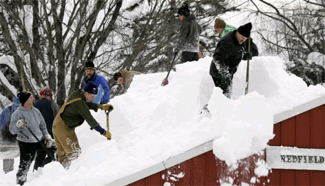  Redfield Volunteer Fire Department volunteers shovel snow off their roof in Redfield, N.Y., Sunday. Lake-effect squalls have dumped nearly 10 feet of snow on parts of the state in the past week. 